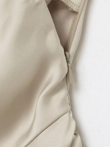 Gros plan sur la fermeture éclair invisible latérale du haut en satin beige doux