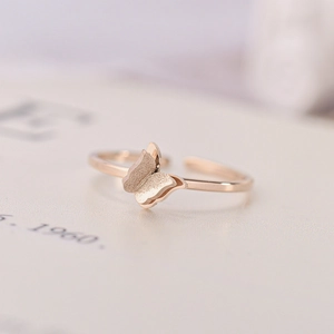 Macro shot of 18K rose gold butterfly ring featuring matte textured wings and a polished band