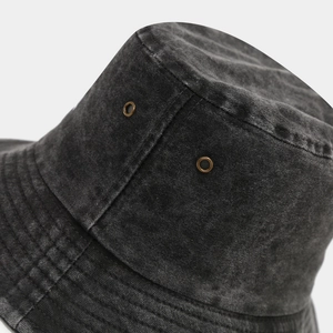 Dettaglio di cappello pescatore in tela nera lavata con occhielli in metallo e cuciture