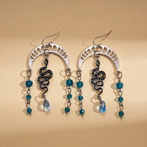 Detail of vintage snake fringe earrings with crescent moon and dark crystal beads