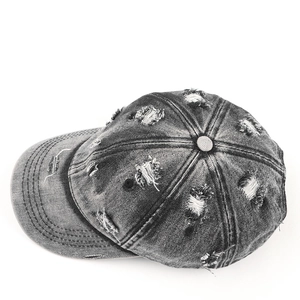 Detailed top view of vintage washed denim baseball cap with distressed ripped accents