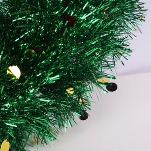 Close-up of green Christmas tinsel garland featuring shiny red and gold metallic sequins