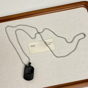 Macro detail of a sleek black rectangular pendant on a silver ball chain necklace