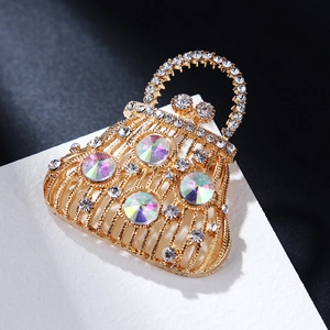 Detailed view of luxury handbag brooch with gold plating and iridescent rhinestones
