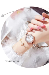 Detail of rose gold women's watch with diamond bezel and matching star bracelet
