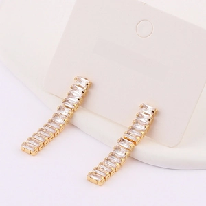 Detailed close-up of long tassel earrings with sparkling rectangular zircons in gold setting