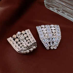 Detailed macro view of sparkling silver rhinestone fan-shaped jewelry on brown silk fabric