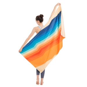 Quick-dry microfiber beach towel with vibrant geometric stripes held by a person