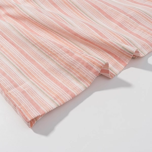 Close-up of pink and white striped fabric with woven cotton-linen texture and neat hem