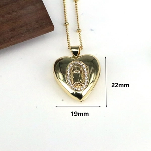 Macro shot of gold heart pendant necklace with virgin mary icon and 22mm x 19mm size labels