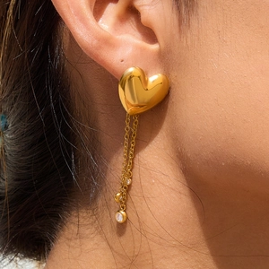 Boucles d'oreilles cœur en plaqué or 18K avec glands en zircon sur un mannequin