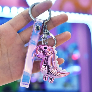 Close-up of cute pink dinosaur acrylic keychain with holographic strap and silver metal clasp