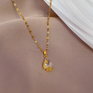 Macro shot of gold waterdrop necklace with deer pattern engraving and clear zircon