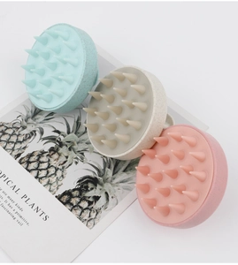 Detailed view of three silicone scalp massage brushes in mint, beige, and pink colors