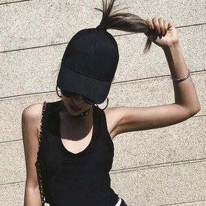 Detail of the high ponytail opening on the back of a black minimalist cotton baseball cap