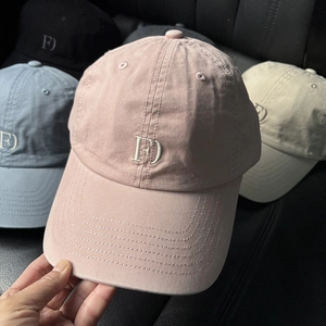 Detail showing embroidered cotton baseball caps in pink, blue, beige, and black colors