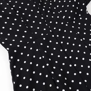 Close-up of black fabric with white polka dot pattern showing material texture and detail