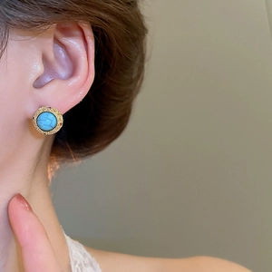 Close-up of model wearing vintage 18k gold plated turquoise stud earring with zirconia