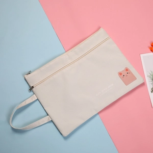 Detail of cute cat patch and double zippers on cream A4 oxford cloth document bag