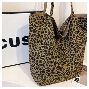 Close-up of leopard print tote bag featuring a gold round logo and durable handles