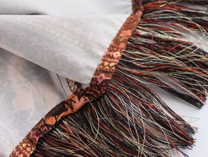 Gros plan détaillé sur tissu à imprimé ethnique avec pompons multicolores vibrants