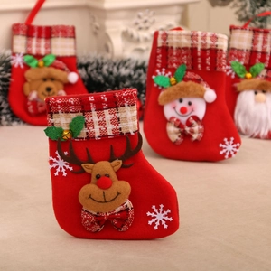 Close-up of a red plush Christmas stocking with reindeer pattern and golden bell detail