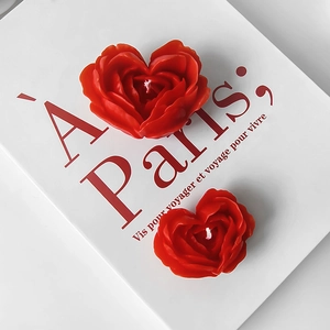 Romantic red heart-shaped rose scented candle placed on a vintage book background
