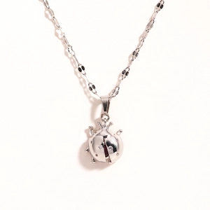 Detailed close-up of a red enamel ladybug pendant with sparkling crystals on a silver chain