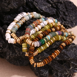 Détail de bracelets en perles heishi bohèmes avec pierres naturelles et entretoises
