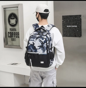 Detail of blue camo travel backpack on model showing large capacity and side mesh pockets