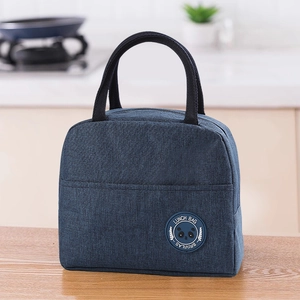 Navy blue oxford fabric lunch bag with panda logo on a light wood kitchen table
