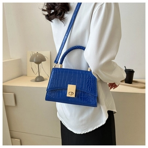 Blue crocodile pattern crossbody bag featuring woven handles and gold metal lock detail