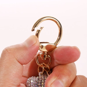 Detail of golden spring snap hook and vibrant rhinestone inlay on cartoon bear keychain
