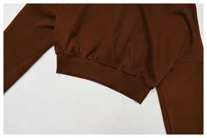 Detail of ribbed hem and cuffs on deep brown hoodie made of thick premium cotton