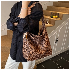 Close-up of leopard print shoulder bag with decorative wooden beads and soft texture
