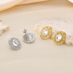 Macro detail of vintage oval stud earrings with large crystal and faux pearl accents