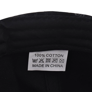 Gros plan détaillé de l'étiquette d'entretien 100% coton sur la casquette noire