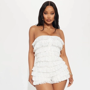 Detailed view of layered white lace ruffles on a strapless slim fit romper for women
