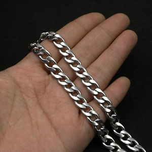 Close-up of thick silver Cuban link chain in hand, hip hop style stainless steel jewelry