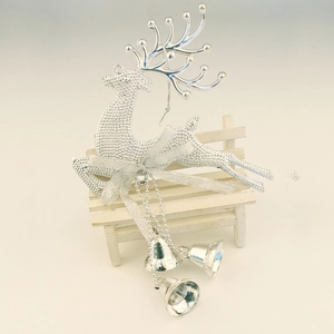 Silver Christmas reindeer hanging ornament with double bells and a bow on a white chair