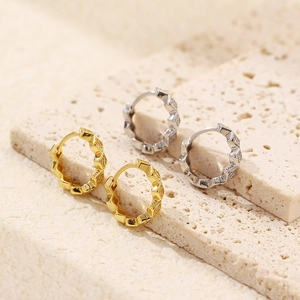 Macro view of geometric S925 sterling silver hoop earrings with diamond-cut textures