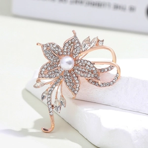Close-up of rose gold flower brooch with white pearl and sparkling crystal detail