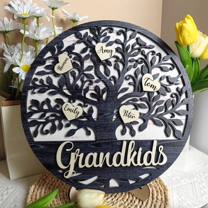 Detailed view of layered wooden family tree ornament with engraved heart names and grandkids text