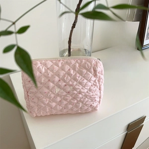 Détail de la trousse de maquillage rose matelassée avec motifs lapins et fermeture