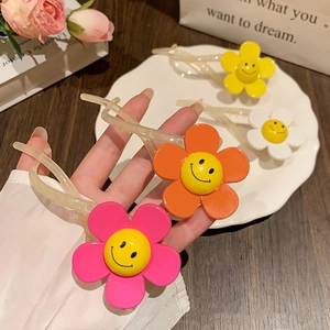 Close-up of vibrant sun flower smile face twist hair clips in four bright colors