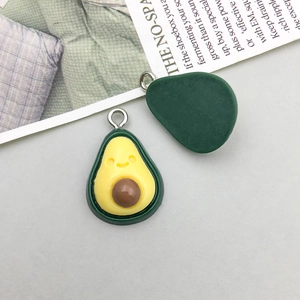 Macro view showing both sides of a resin avocado charm with a cute smiley face