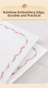 Detail of white waffle texture dishcloth with colorful rainbow embroidered wave edges