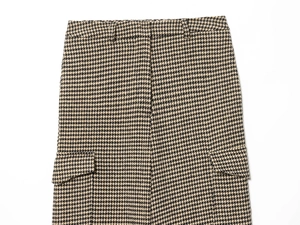 Detail view of high waist houndstooth pants with yellow and black patterns and flap pockets