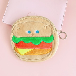 Close-up of a plush hamburger coin purse with embroidered cartoon face and metal zipper