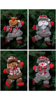 Close-up of plush reindeer, santa, bear and snowman ornaments on a green Christmas tree
